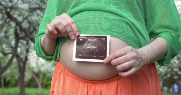 Pregnant Woman Holding a Sonogram Image