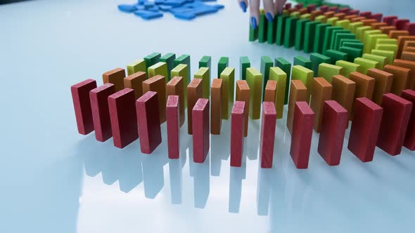 Line up of Dominoes in Rainbow Falling Colors with LGBT Colors of a Hand