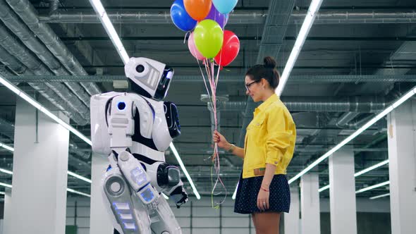 Colourful Balloons Are Being Given By a Girl To a Robot