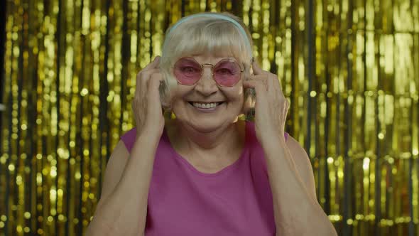 Senior Old Woman Dances, Listens Music on Headphones. Relaxing, Enjoying, Having Fun, Smiling