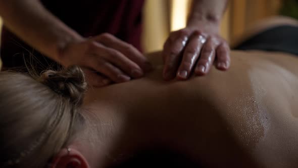 Professional Masseur Gives a Relaxing Back Massage to a Young Woman Using Oils Female Enjoy a