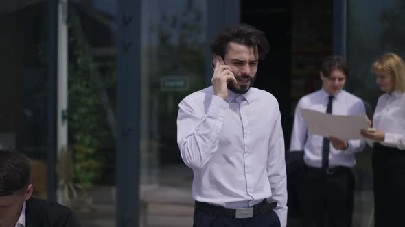 Portrait of Confident Bearded Man Persuading Partners Talking on Phone Walking in Slow Motion