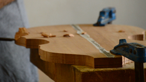 Luthier Working with a Chisel in a Instrument