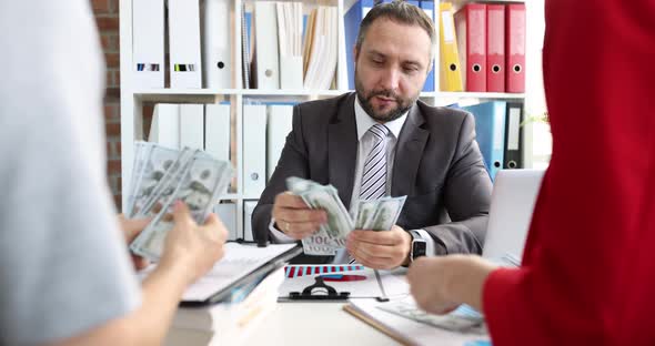 Team of Business People is Counting Money at Working Table