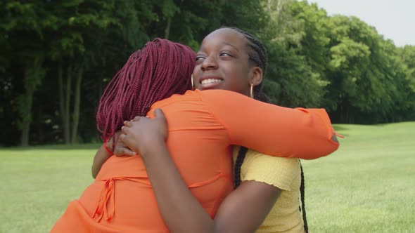 Happy Cute Black Teenage Girl Embracing Mom with Love in Park