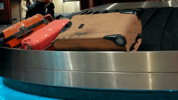 Suitcases On Conveyor Belt Waiting For Owners