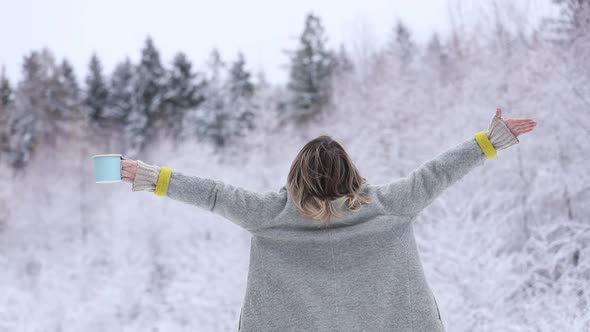 Beautiful happy woman in coat in a snow forest.