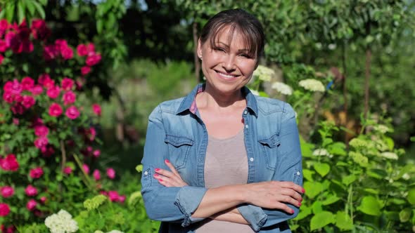 Portrait of Beautiful Middleaged Woman in Blooming Summer Garden