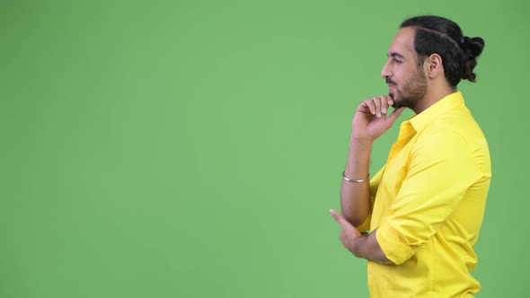 Profile View of Young Happy Bearded Indian Businessman Thinking