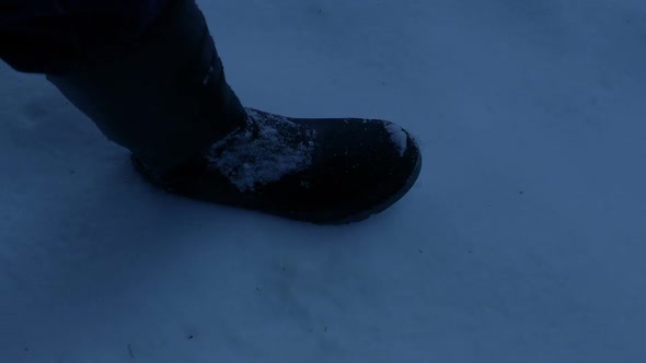Boot Leaves Footprint In Snow In The Evening