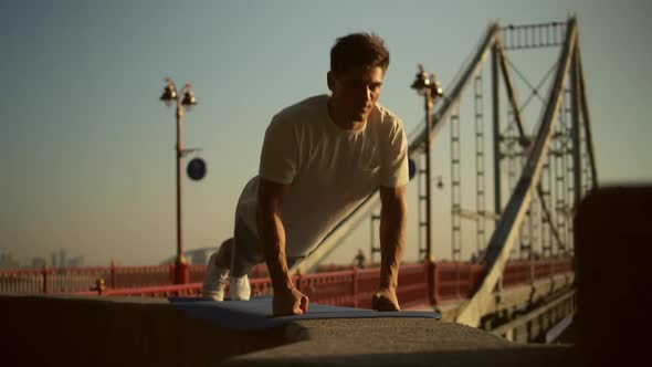 Man Doing Push-ups By the Bridge