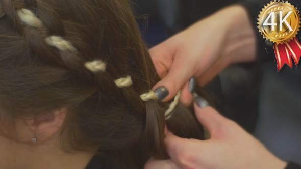 Stylist Hairdresser is Weaving a Braid