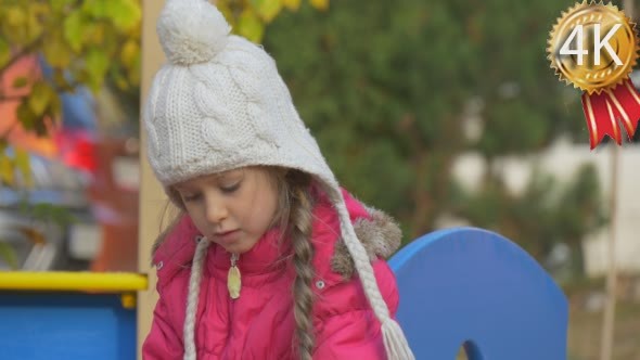 Little Girl Plays On The Playground In The Yard