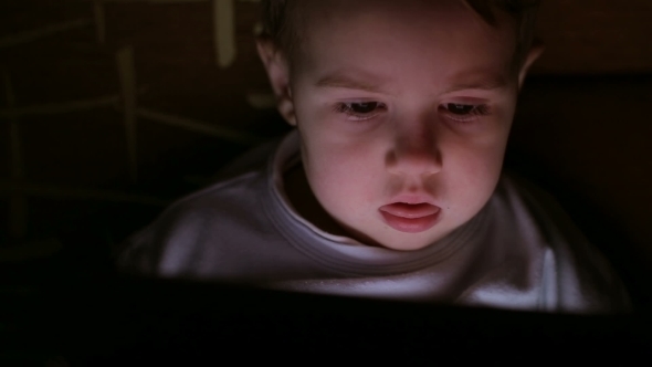 Boy Browsing Tablet Pc In The Dark