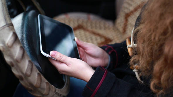 Girl Uses Tablet in the Car