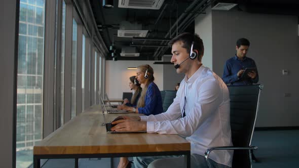 Man Using a Headset While Working in Call-center Office