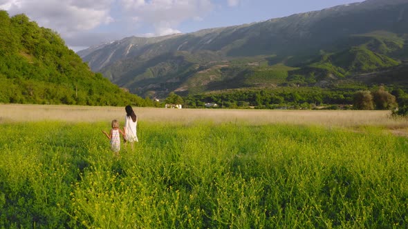 morning walk through flowery meadow in the valley. maternal bond, family and affection concept
