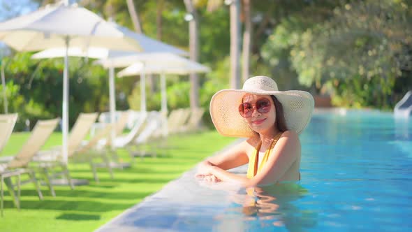 Young asian woman enjoy around outdoor swimming pool for leisure