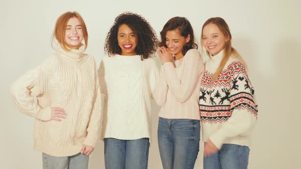 Four young beautiful smiling gorgeous girls in trendy winter sweaters