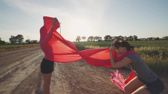 Woman Fashion Photographer Photographing on Camera a Stylish Young Woman Model with Red Hair and