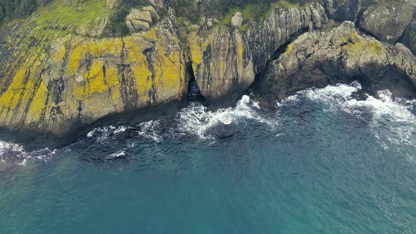 aerial view of waves crashing rocks