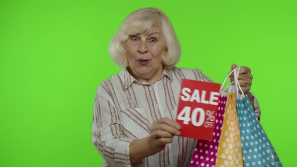 Cheerful Grandmother with Shopping Bags Showing Sale 40 Percent Off Banner Text Advertisement