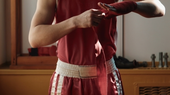 The Young Boxer Pulls Red Bandage On Hands
