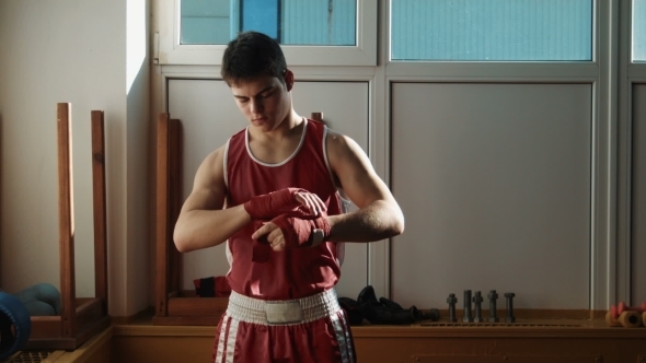 The Young Boxer Pulls Red Bandage On Hands