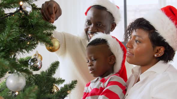 Happy Family Decorating Christmas Tree at Home