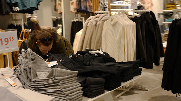 Woman Choosing Clothes During Shopping alt