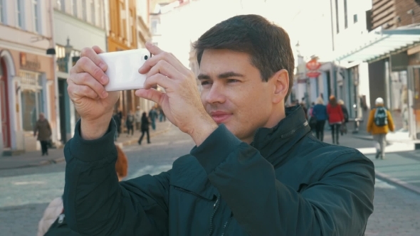 Male Tourist Taking Photos Of Tallinn Streets alt