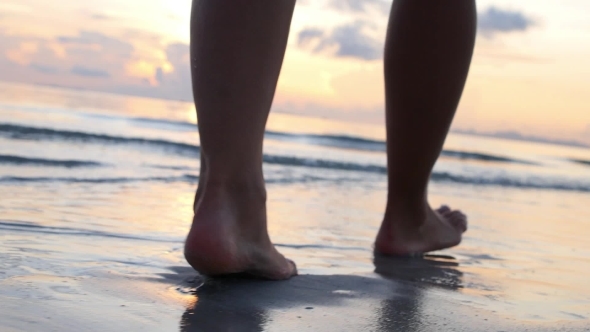 Woman Legs Walking On Beach In Sea Waves