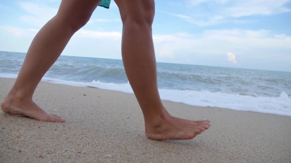 Woman Legs And Feet Walking On Beach In Sea Foam 