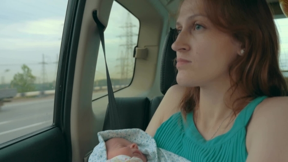 Young Mother Holding Newborn In The Car