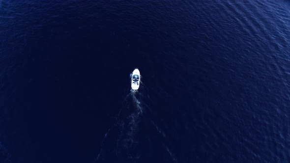 White Small Boat Sails on Blue Deep Water  Tracking Drone Shot