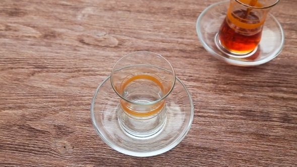 Pouring Tea Into a Cup On a Wooden Table