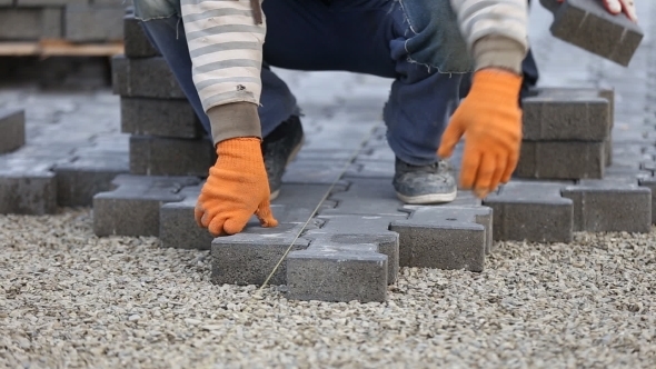 Worker Puts Sidewalk Tile