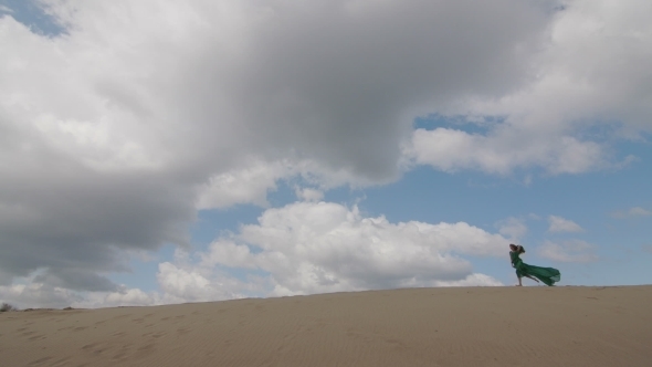 Beauty Girl In Green Dress Running On Sand Dune