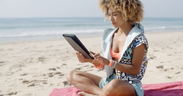 Woman Uses Touchpad Tablet On The Beach
