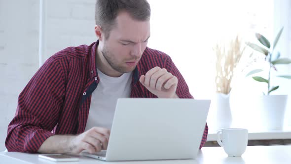 Sick Young Man Coughing and Working on Laptop Throat Infection