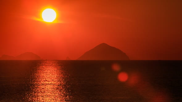 View of Big Sun Disk Sun-path Across Sea against Blurry Islands