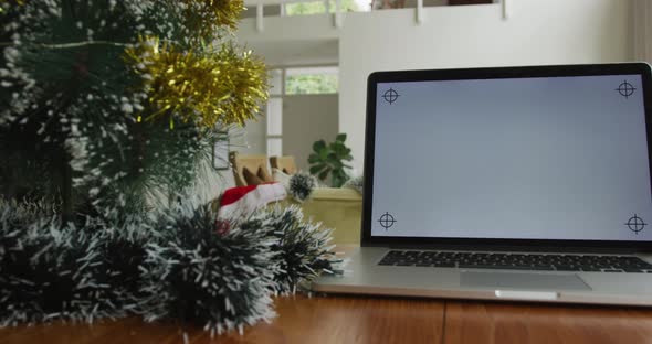 Close up of laptop with copy space on screen, sitting on table in living room at christmas