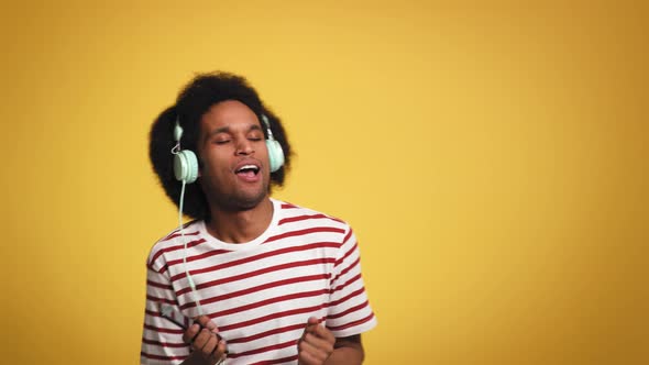 Young man having fun during listening music and dancing