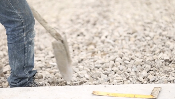 Worker Distributes Gravel