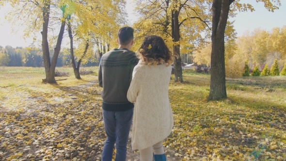 Boy And Girl Walk On Autumn Alley