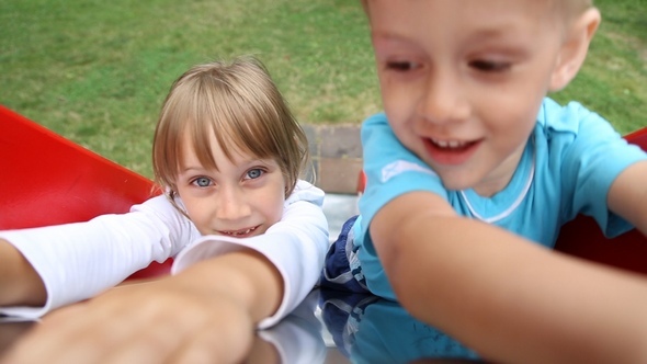 Children Riding on a Sliding Board alt