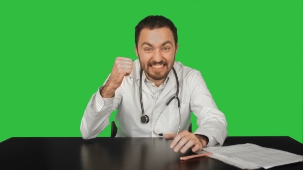 Smiling Male Doctor At Medical Office On a Green