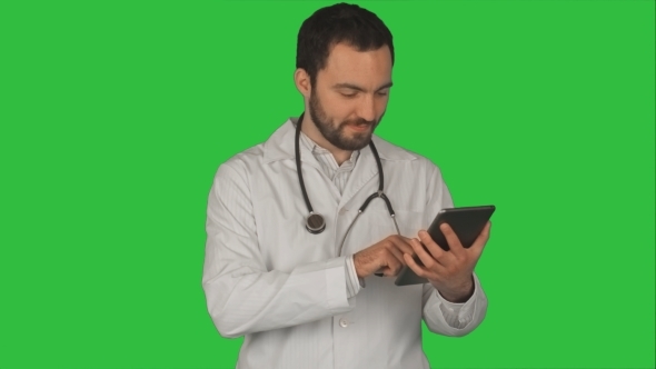 Happy Doctor Using Digital Tablet On a Green
