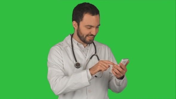 Happy Doctor Using His Smartphone  On a Green