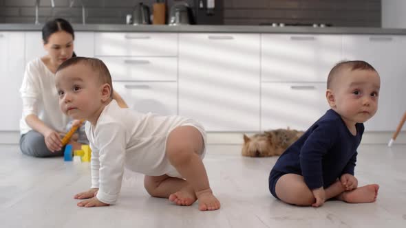 Asian Triplets Sitting on Kitchen Floor with Mom